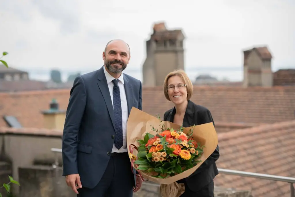 eine Frau mit einem Blumenstrauss und ein Mann lachen in die Kamera