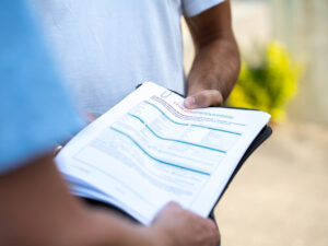 ein Bericht auf einem Klemmbrett, das gehalten wird